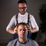Barber massaging head of client